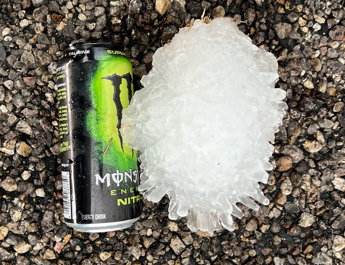 A piece of hail estimated to be over 7 inches—it’s on the ground next to an energy drink can to get an approximate measurement of its diameter.